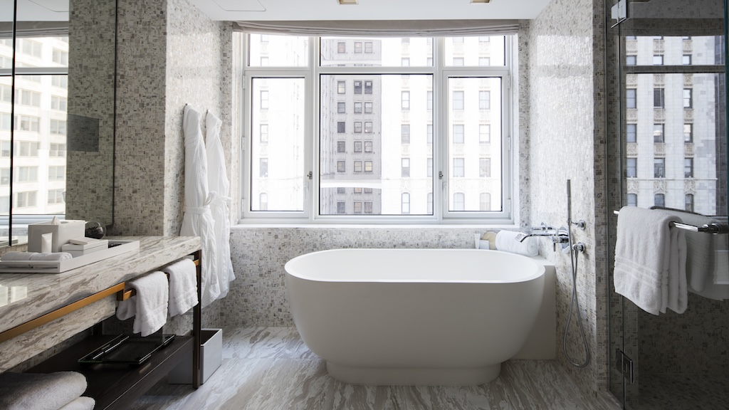 Hotel bathroom featuring large tub by window