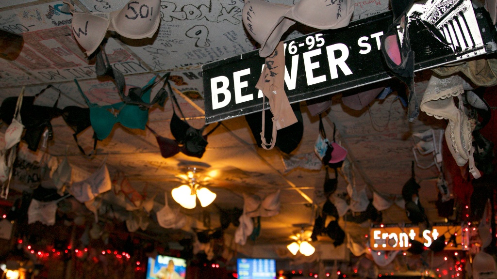 Bras hanging from the ceiling at Jeremy's Ale House, with street sign for 76-95 Beaver St.