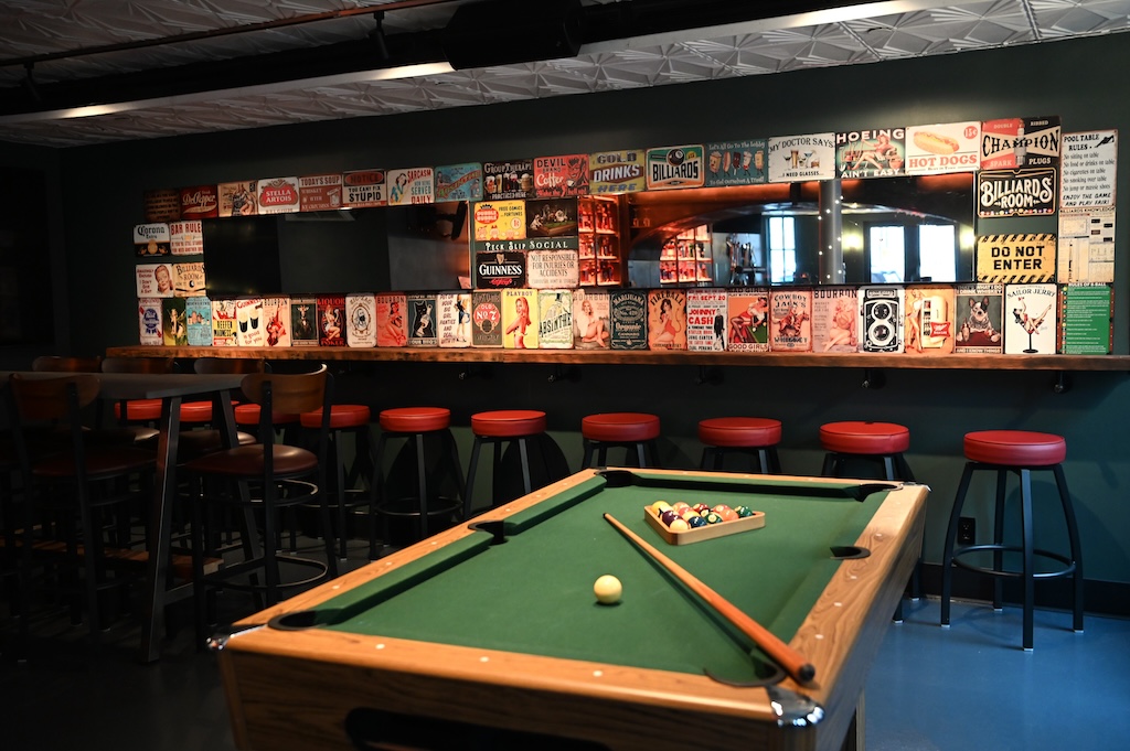 Pool table with mirrored back bar and vintage ads in background