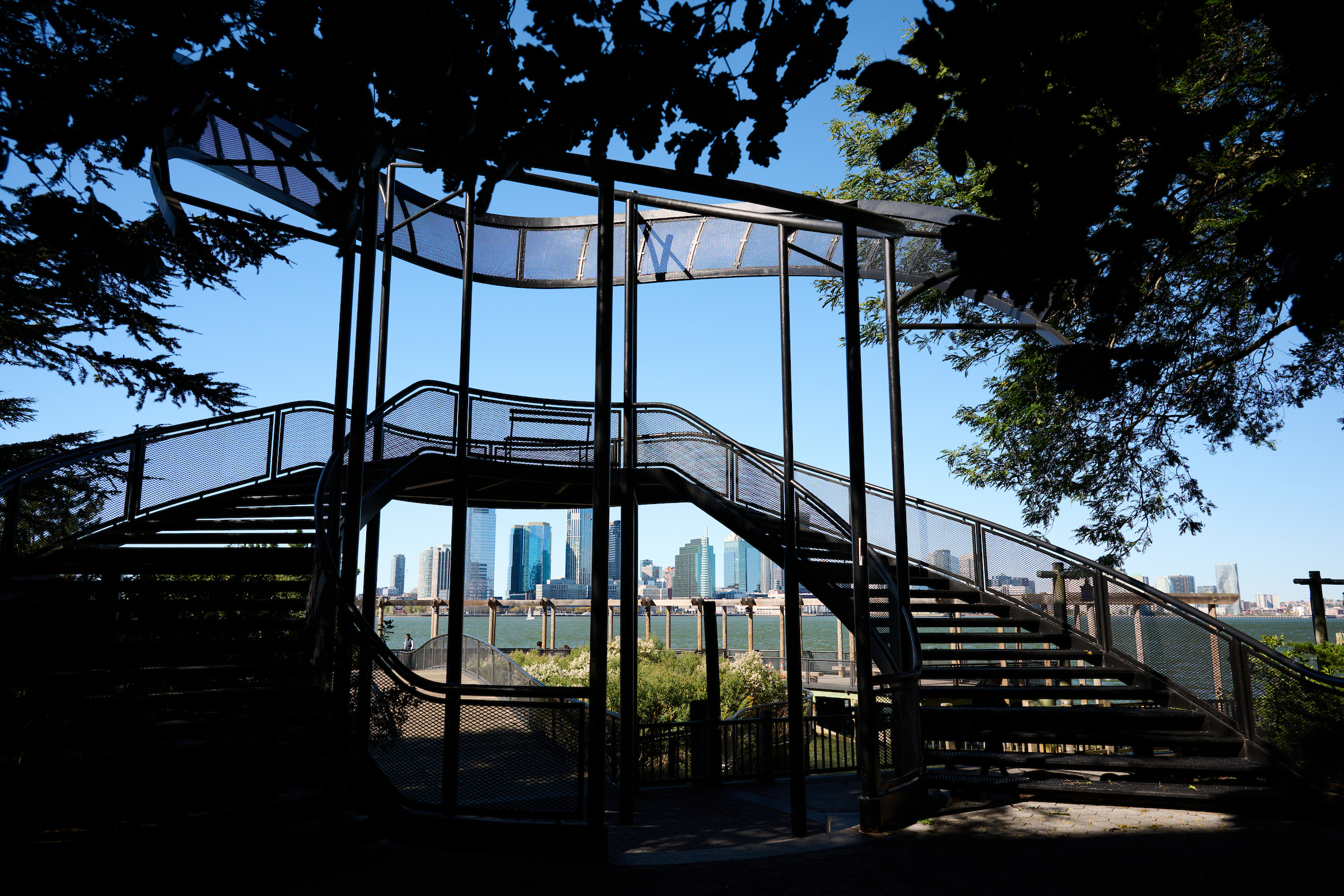 A staircase structure on the waterfront at a tree-covered park in Lower Manhattan.