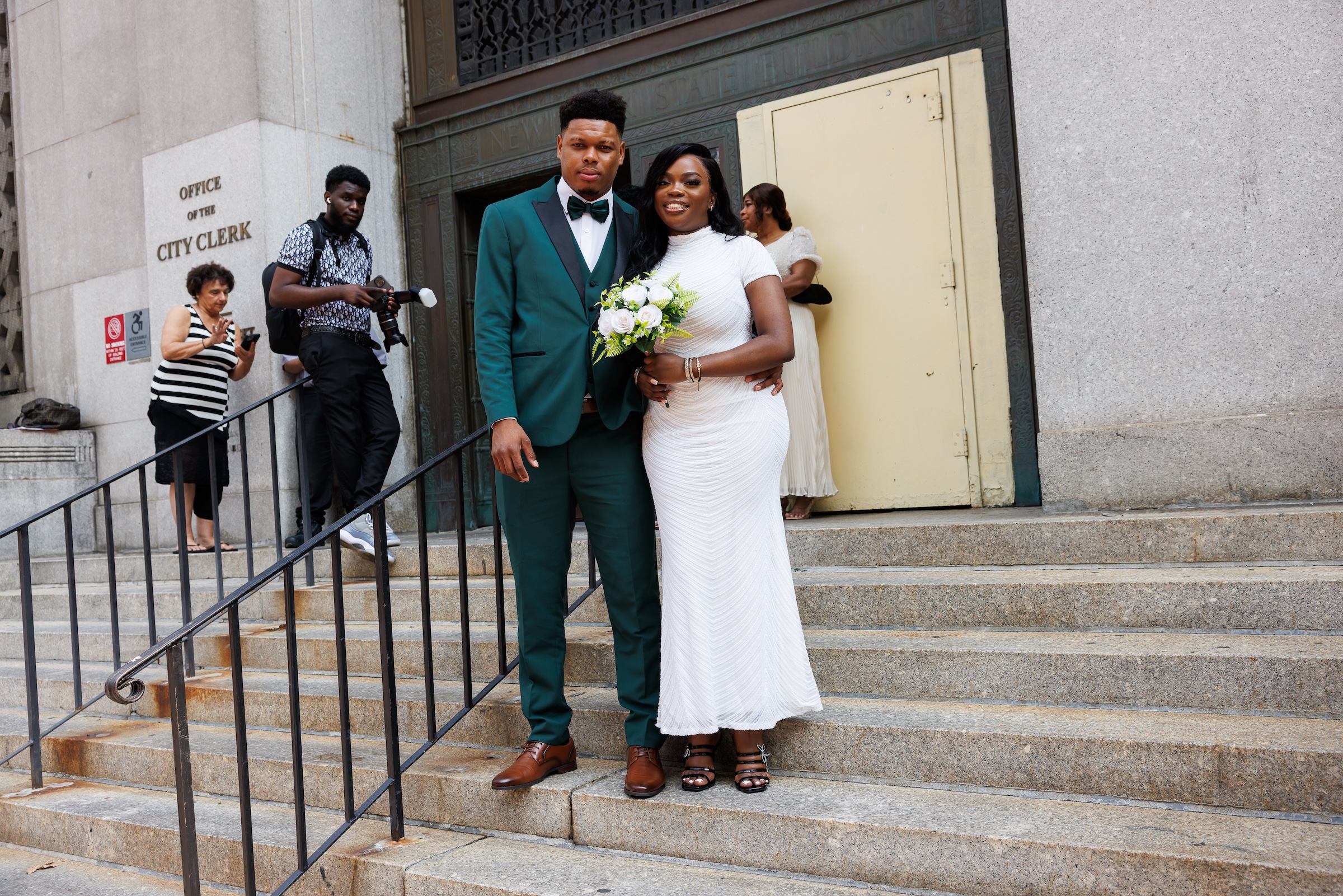 Wedding couple pose on steps of City Clerk's office in Lower Manhattan.